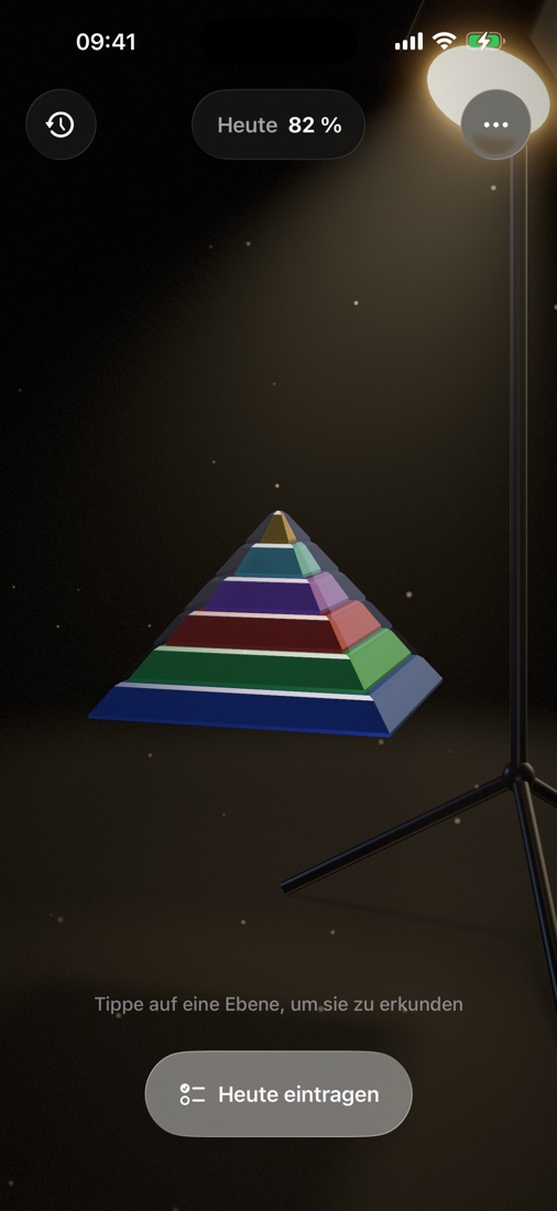 Die Maslow-Pyramide — sechs farbige Schichten im warmen Licht eines Studioprojektors